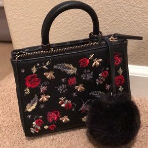 Small handbag with gold/red designs on the front.